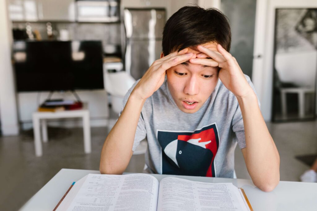 Criança estressada estudando, mostrando o cansaço e o que evitar dizer para os filhos sobre cobranças.